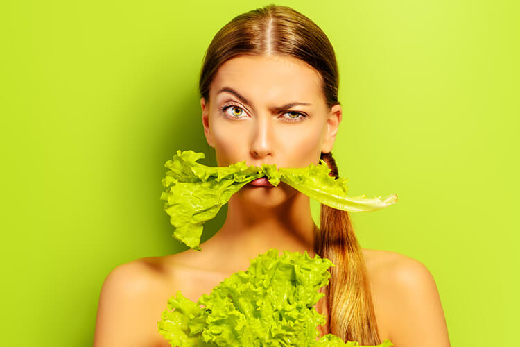 Vegan diet, close up, lady with leafy vegetable on her mouth